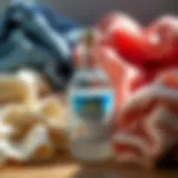 Bottle of vinegar next to laundry detergent and various fabrics